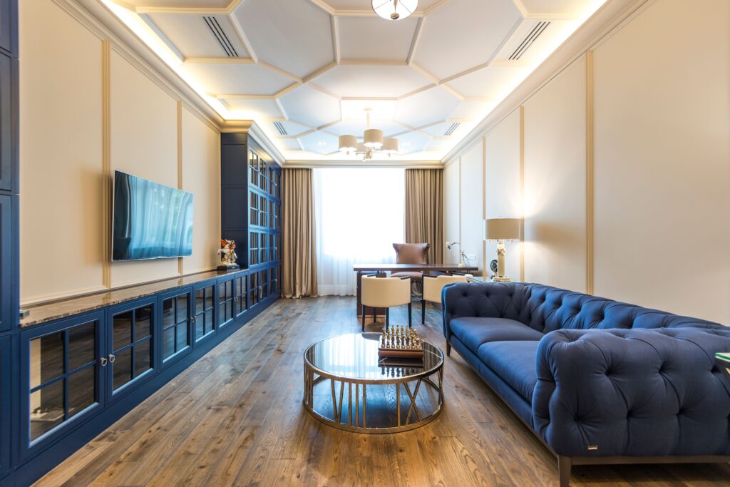 A luxurious apartment interior featuring a blue sofa, modern decor, and elegant lighting.
